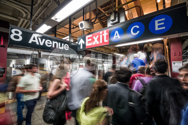 subway station - busy platform with people in motion blur on 8th Ave with A C and E exit sign in summer