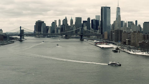 aerial tracking boat on East River with Freedom Tower Manhattan Bridge and skyline in New York City NYC