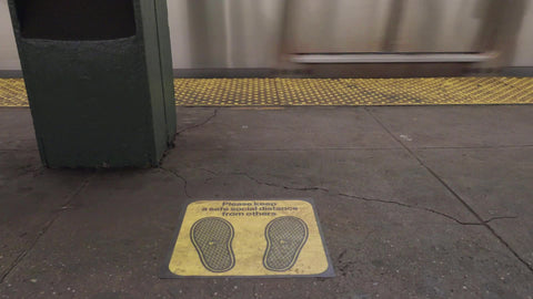 subway train arriving in station platform with social distancing sign on floor - 6 feet distance in New York City
