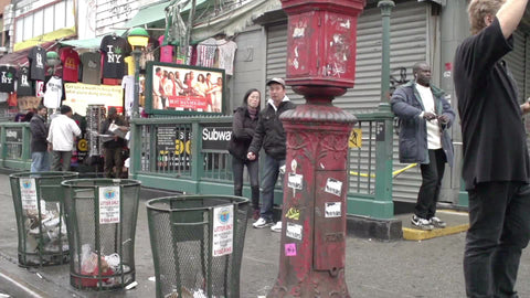 Asian man leaning on Canal Street Chinatown subway entrance giving middle finger in slow motion NYC