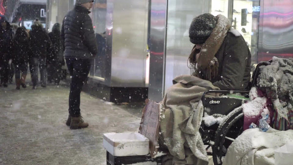 snowflakes falling and people passing by homeless man in wheelchair on ...