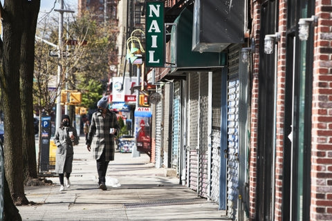 masked couple walking with coffee in street NYC