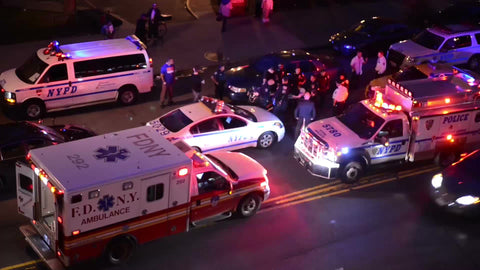 crime scene - NYPD police cars and FDNY ambulance with flashing lights at night in NYC