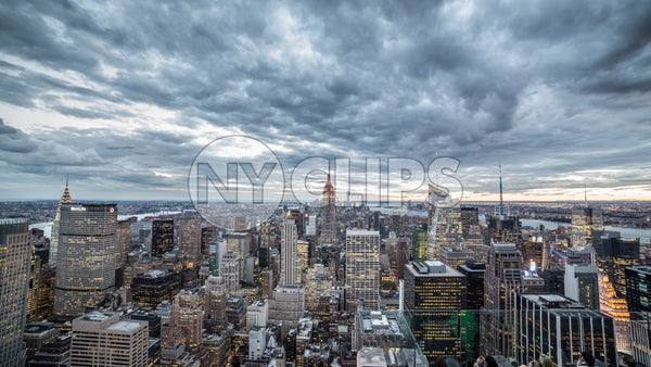 Empire State Building and Manhattan skyscrapers from high view with cold blue clouds overhead in early evening