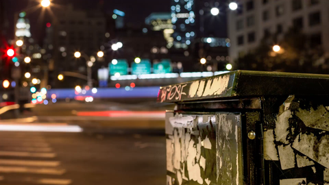 zooming out from busy intersection in Downtown Manhattan with Freedom Tower out of focus in background - 4K timelapse at night in NYC