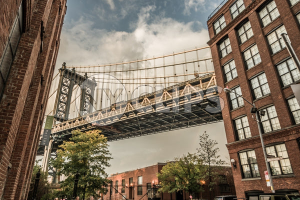 Manhattan Bridge street view between two buildings in Brooklyn during day in NYC