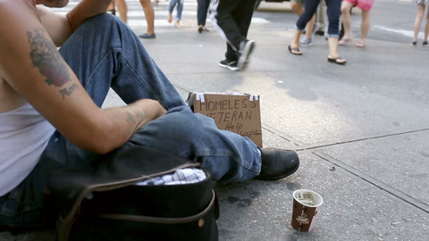 homeless man sitting on sidewalk - faceless veteran with sign and cup in Union Square Manhattan New York City