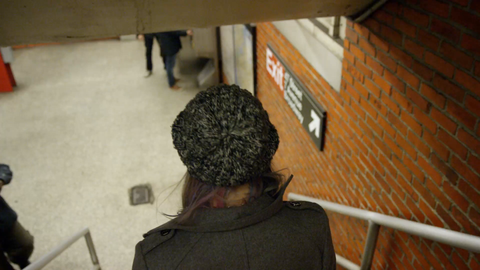 woman entering subway station - walking down stairs and appraching turnstile - reaching in pocket for metro card - missing the train in 4K slow motion in NYC