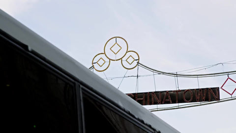 welcome to Chinatown sign with bus driving