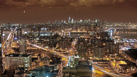 Manhattan skyline from Brooklyn  at night - high view with moon in burgundy sky in New York City