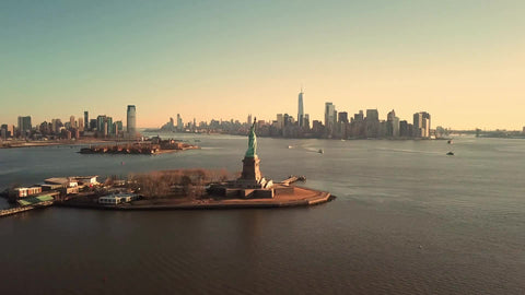 far shot Statue of Liberty circling daytime Manhattan skyline New York City NYC 4K and 1080 HD