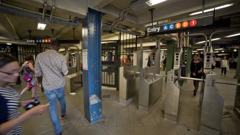 busy subway station in summer - people swiping at turnstiles in NYC