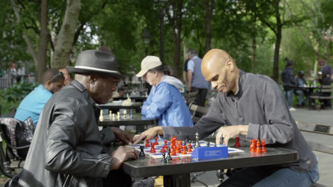 two men playing chess at tables in Washington Square Park in Spring - masters hitting timer and making moves in 1080 and 4K NYC