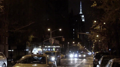 taxi cab on Lower Fifth Ave at night with famous skyscraper Empire State Building in background