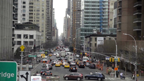 Ed Koch Queensboro Bridge sign moving overhead tram over busy street with cars in traffic in Manhattan 1080 HD in NYC