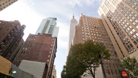 driving toward Empire State Building with upward angle on sunny day