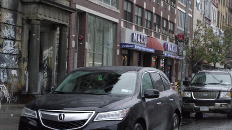 driving past 190 Bowery gritty graffiti building on Houston Street on rainy day in NYC
