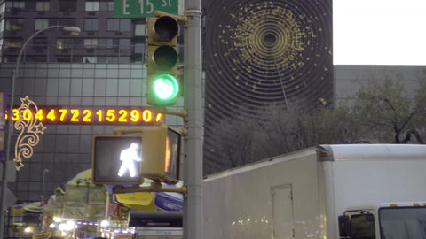 cars driving in Union Square - panning from numbers ticker to taxi cab in early evening