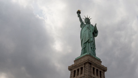 Statue of Liberty on base on cloudy day - 4K full shot upward angle timelapse in New York City