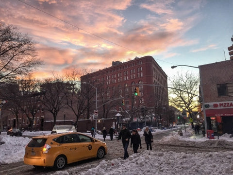 caravan taxicab on Lower East Side of Manhattan - people walking in snow - snowing at sunset in winter