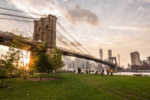 people watching sunset and Manhattan skyline from Brooklyn Bridge Park in NYC