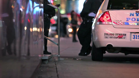 police hanging out leaning on NYPD car in Times Square at night in New York City