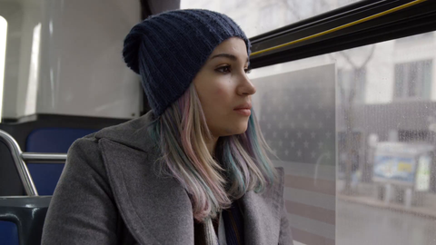 woman on moving bus - traveler commuting on MTA public transportation on depressing grey cold winter day - 4k in New York City
