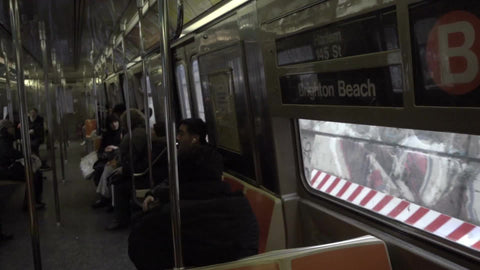 panning across B train, subway with graffiti on either side of window view - passengers riding in 1080 HD in NYC