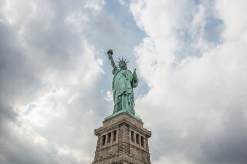 Statue of Liberty - full view - blessed blue sky and light beaming through clouds on summer day