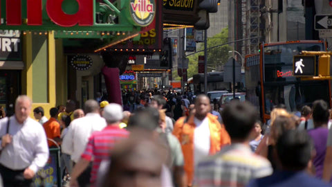 people walking with colorful jackets in Times Square on bright sunny day in summer or spring in NYC