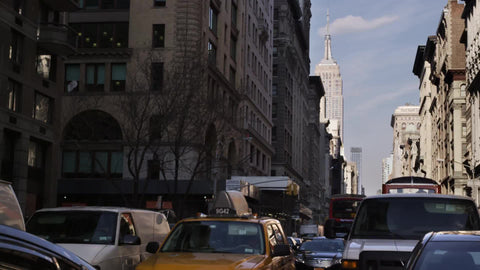 cars stuck in gridlocked traffic on 5th Avenue with Empire State Building in background on Manhattan day