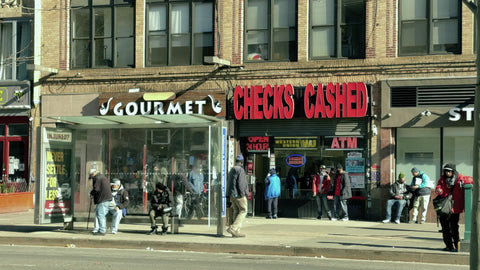people outside checks cashed sign in Harlem 125th street in winter New York City NYC