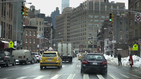 driving on Varick Street in winter - snow on 7th avenue with cars in traffic and Freedom Tower in background in Downtown Manhattan NYC