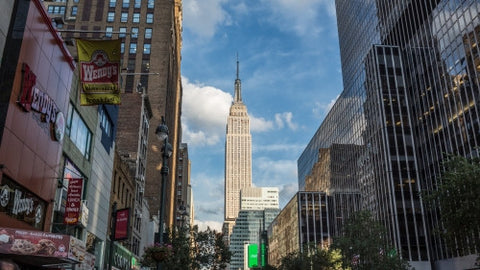Empire State Building view from 34th Street and the west side of Manhattan on summer day with bright blue sky