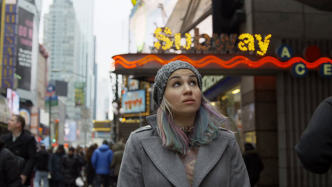 attractive female tourist looking around Times Square signs outside subway station sign - overwhelming bright lights - slow motion 4K NYC