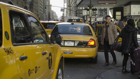 tourist getting into taxicab at taxi stand outside Penn Station on fall day in Manhattan NYC