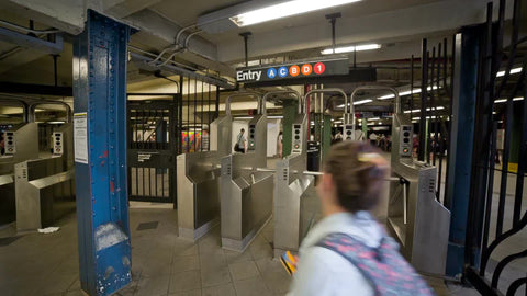 high school girl swiping Metro Card in subway train station in summer - NYC