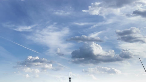 Empire State Building and Manhattan skyscrapers in cityscape tilting down quickly with clouds overhead - timelapse of NYC