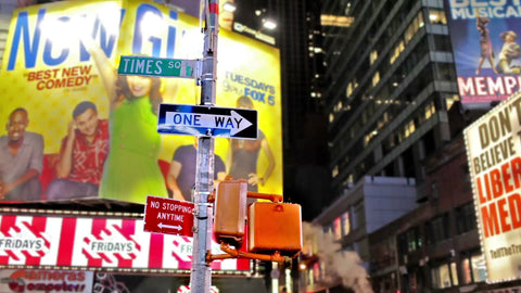 Times Square sign at night with construction smoke rising in background