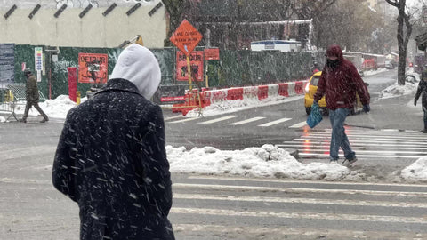 man stepping over ice and snow in blizzard snowing in winter East Village New York City NYC