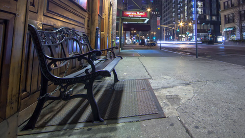 pulling back slowly from bench on Manhattan street outside bar at night - 4K timelapse
