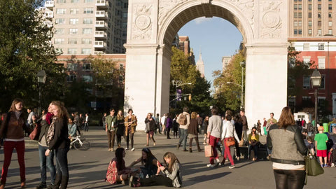 people walking through arch on sunny day - playing and having fun in Washington Square Park in summer