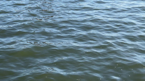 East River water tilting up to Brooklyn Bridge and American flag in New York City NYC