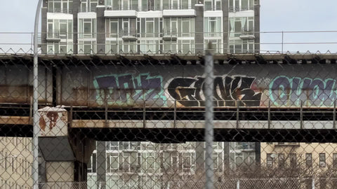driving past graffiti elevated subway train track platform in Williamsburg Brooklyn New York City NYC
