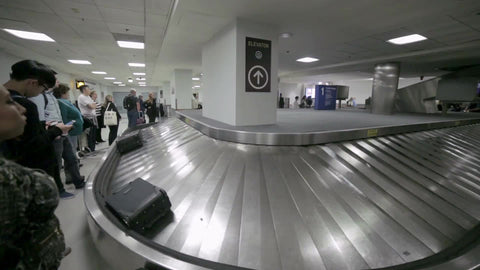 suitcases on conveyor belt at LaGuardia Airport baggage claim