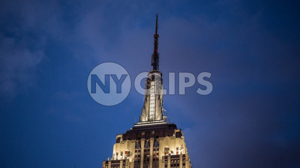 top of Empire State Building with evening lights on at night