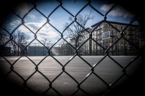 empty basketball court in Harlem winter day view through fence
