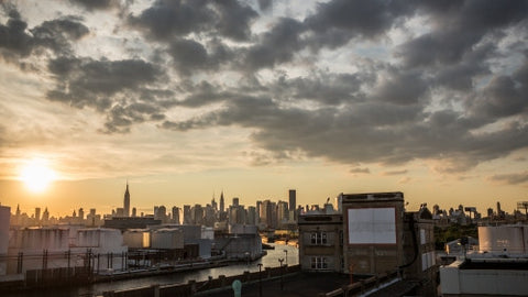 Manhattan skyline view from Brooklyn at sunset and clouds overhead in beautiful sky