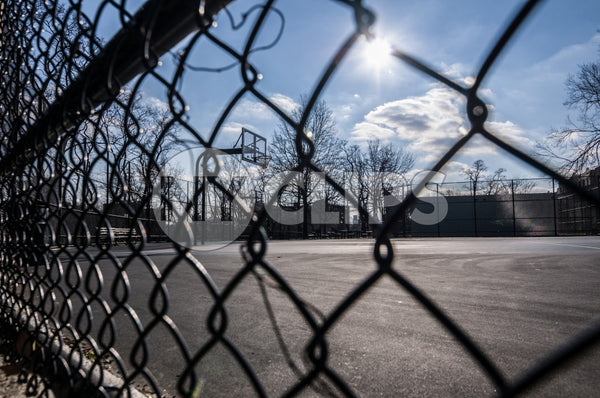 gritty fence and Harlem basketball court on sunny winter day