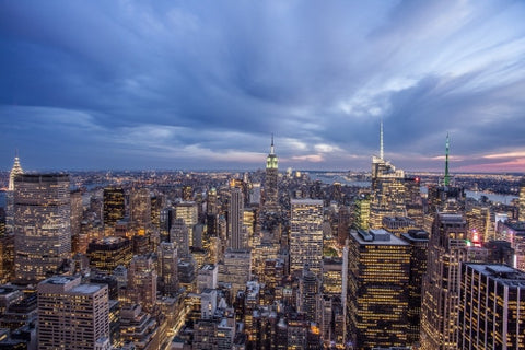 Empire State Building and Manhattan cityscape at night with lit up skyscrapers from high view